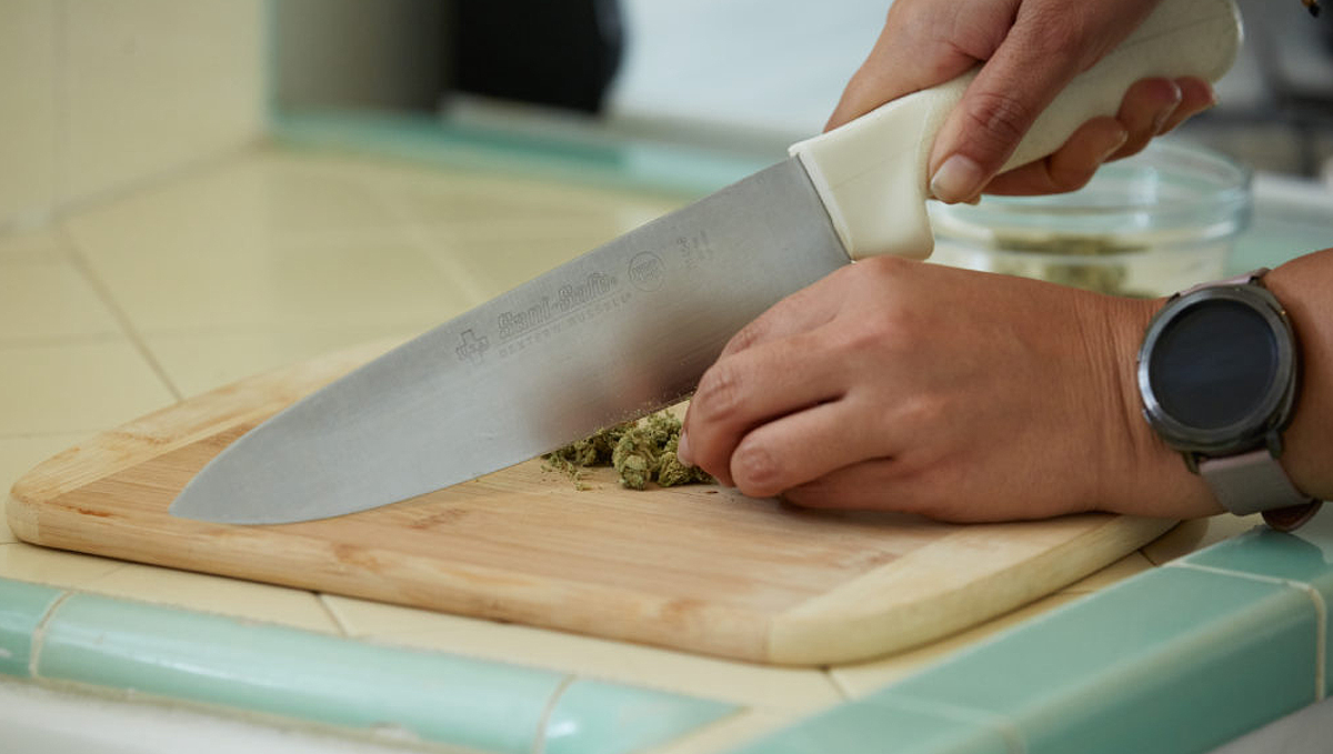 Chopping cannabis with a knife to grind it