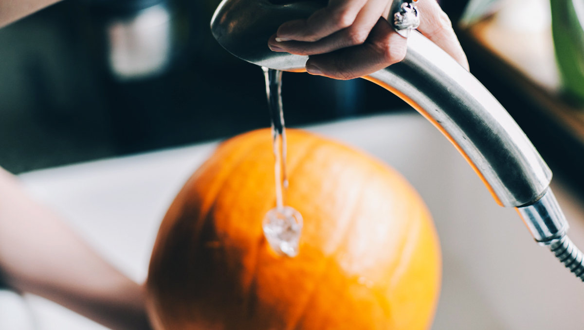 Filling the pumpkin bong with water.