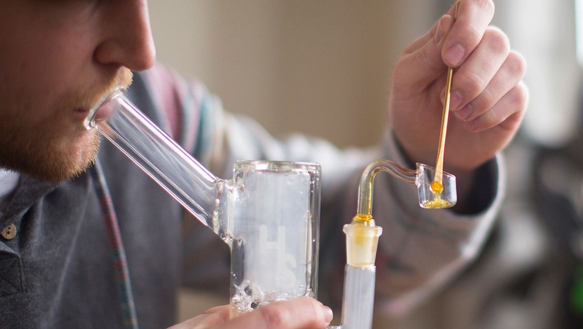 Cannabis Shatter: What Is It, How To Make And Smoke THC & CBD Hash Oil: A cropped photo of a young man dabbing shatter