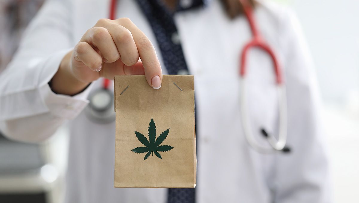 Mississippi, USA, Has Legalized Medical Cannabis: A woman doctor holding a plain brown paper bag with a cannabis leaf logo