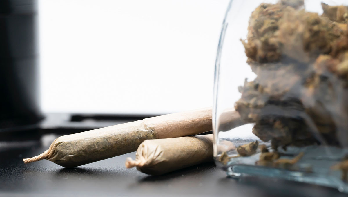 Thailand Lifts the Ban on Cannabis Opening the Floodgates of Legal Trade: A glass jar with marijuana buds and two pre-rolls lying next to it Thailand Lifts the Ban on Cannabis Opening the Floodgates of Legal Trade: A glass jar with marijuana buds and two pre-rolls lying next to it