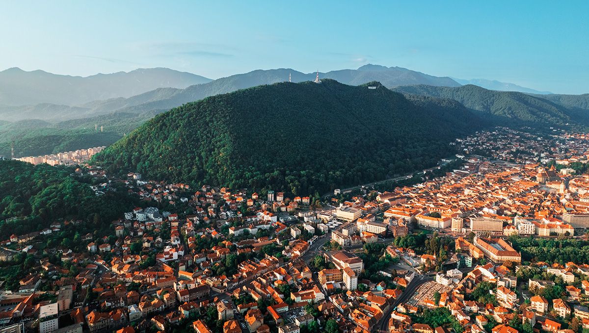Weed in Romania: Cannabis Legal Status Guide: A bird's eye view of a city in a mountain valley Weed in Romania: Cannabis Legal Status Guide: A bird's eye view of a city in a mountain valley