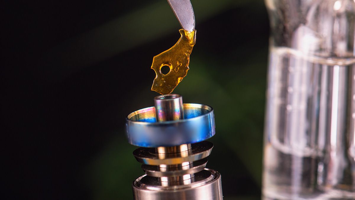 Cannabis Shatter: What Is It, How To Make And Smoke THC & CBD Hash Oil: A piece of shatter being placed on the heating element of a dab rig