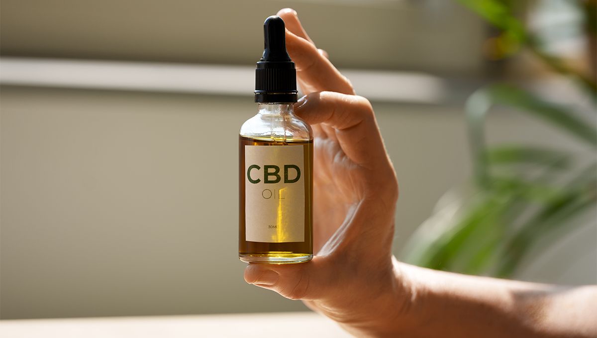 Weed in Florida: Cannabis Legal Status Guide: A person's hand demonstrating a CBD bottle Weed in Florida: Cannabis Legal Status Guide: A person's hand demonstrating a CBD bottle