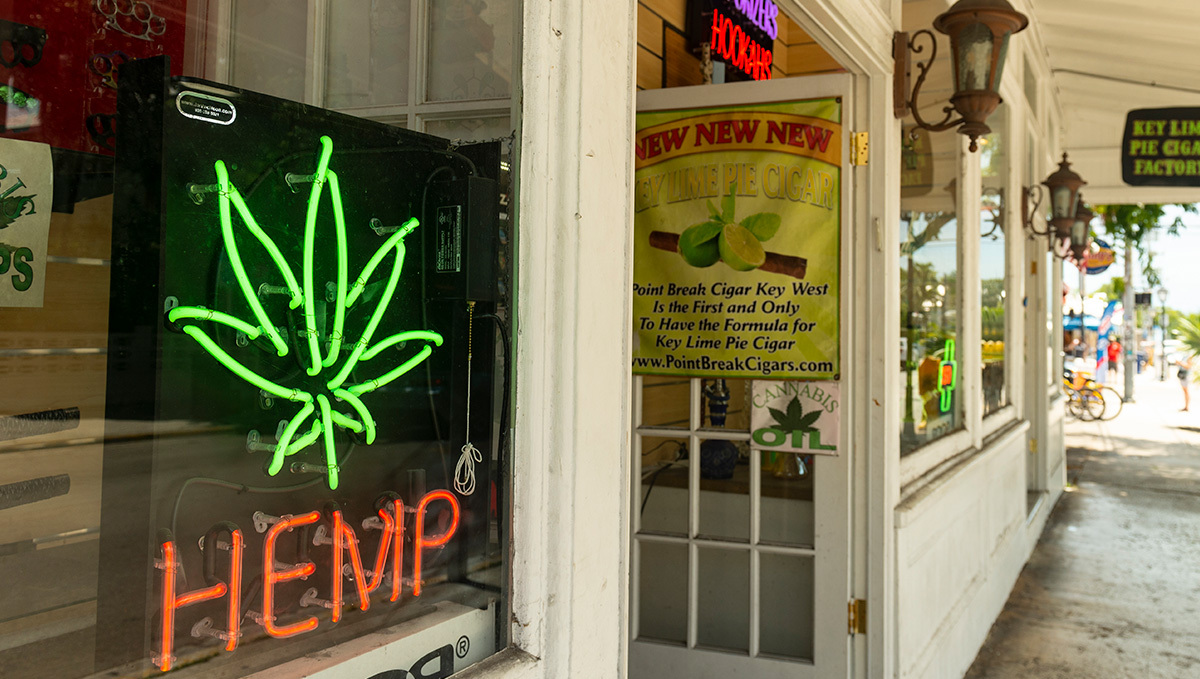 Switzerland Will Allow Recreational Weed Sales as a Pilot Program: The front of a tobacco shop with a cannabis leaf sign and the word 'hemp' in the window